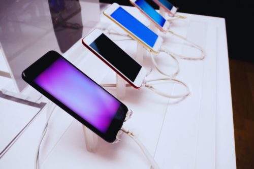 Plusieurs smartphones Android alignés sur une table de présentation, tous connectés et en charge.